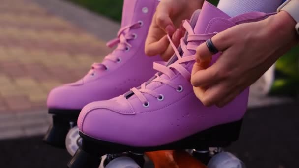lány kötött csipke vintage görkorcsolya, közelkép a kezét, rózsaszín görkorcsolya zöld fű háttér - Felvétel, videó