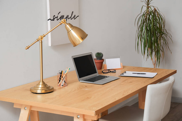 Moderní pracoviště s notebookem a lampou na pokoji - Fotografie, Obrázek