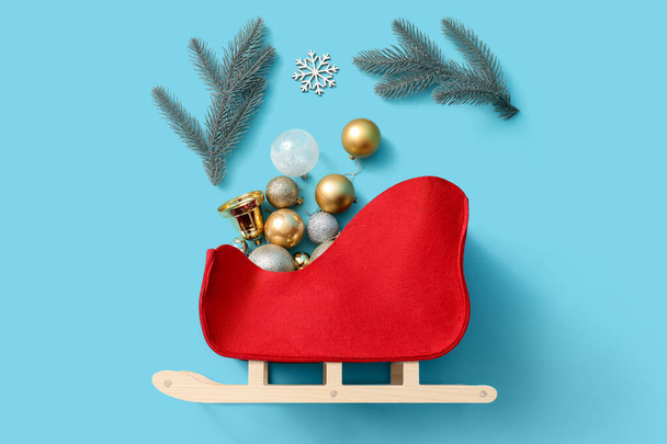 Összetétel dekoratív szánkó és gyönyörű karácsonyi dekoráció színes háttér - Fotó, kép