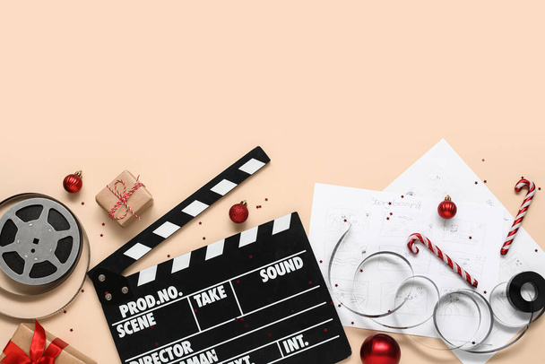 Composition with movie clapper, reels, storyboards and Christmas decorations on color background - Photo, Image