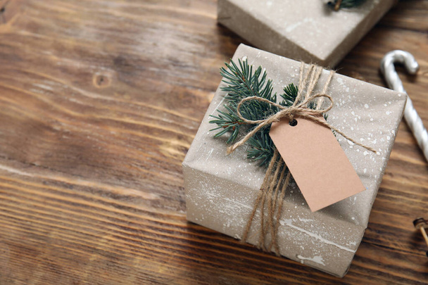 Mooi kerstcadeau met blanco tag op houten achtergrond - Foto, afbeelding