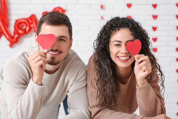 Mladý pár s papírovými srdíčky na Valentýna doma - Fotografie, Obrázek
