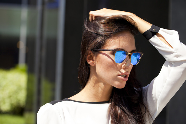 Business woman with blue mirrored sunglasses - 写真・画像