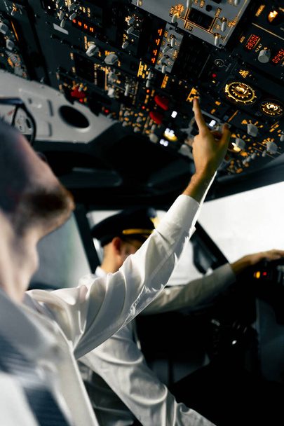 Кабіна літака Пілоти перевіряють електроніку літака натисканням кнопок Підготовка пасажирського авіалайнера Симулятор польоту заднього виду - Фото, зображення
