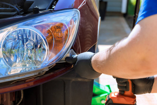 Réparateur assemblant un phare d'automobile sur la voiture pendant la réparation automobile - Photo, image