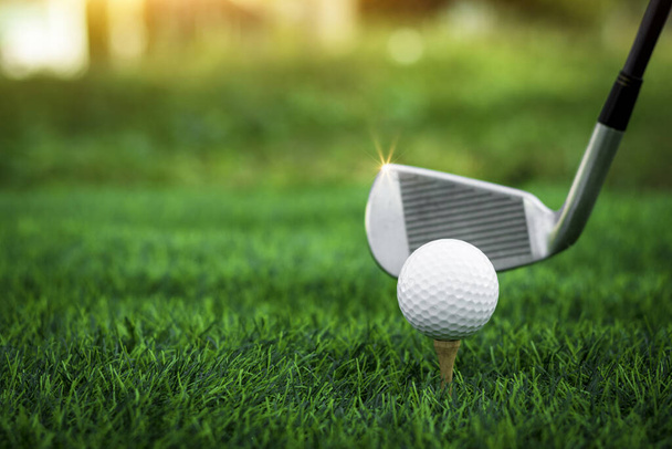 Golf piłka zbliżyć się na trawie tee na zamazanym pięknym krajobrazie tła golfowego. Koncepcja sportu międzynarodowego, które opierają się na umiejętnościach precyzyjnych dla relaksu zdrowotnego. - Zdjęcie, obraz