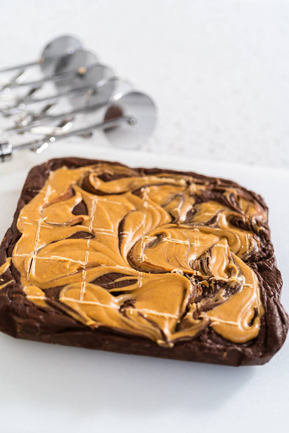 Scoring chocolate fudge with peanut butter swirl for cutting into small pieces. - Photo, Image