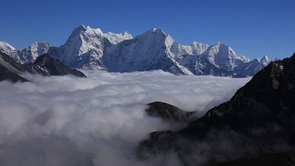 Alte montagne dell'Himalaya raggiungono da un mare di nebbia, Sagarmatha Nationalpark, Nepal. - Foto, immagini