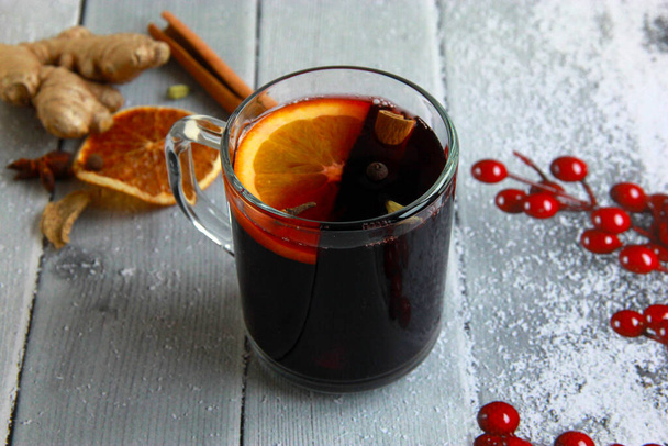 Hot mulled wine with orange and spices in glass with fresh orange and spices - Photo, Image