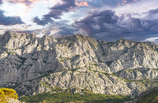 Pohled na skalnatou horu a kontrastní oblačnou oblohu. Chorvatsko - Fotografie, Obrázek