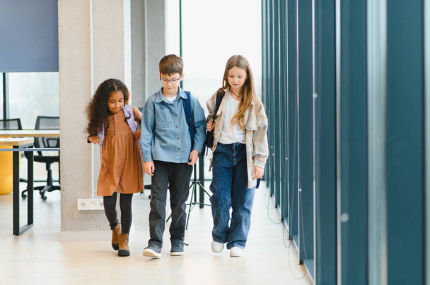 Portrait of kids standing in elementary school hallway. - Fotografie, Obrázek