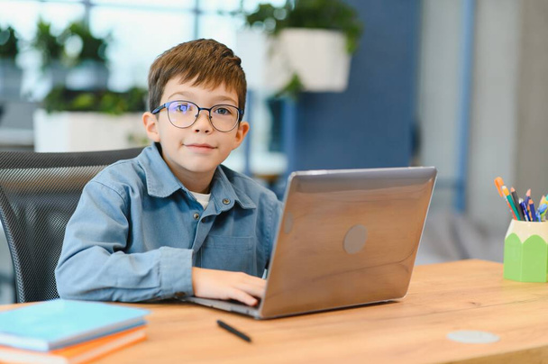 Cheerful boy studying computer in beautiful style. Online training. - Foto, Bild
