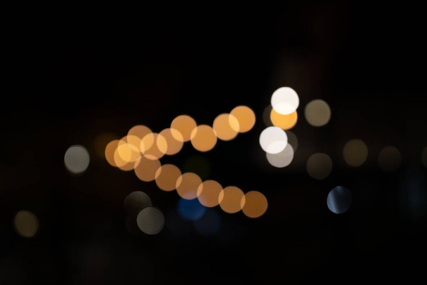 Decoratieve outdoor string lichten 's nachts, Defocused Achtergrond, nachtleven in de stad achtergrond, feest tijd met bokeh ballen - Foto, afbeelding