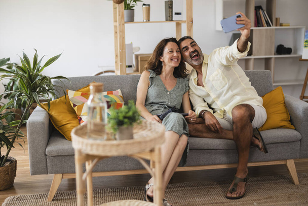 dospělý pár vzít selfie v obývacím pokoji - Valentýna - - Fotografie, Obrázek