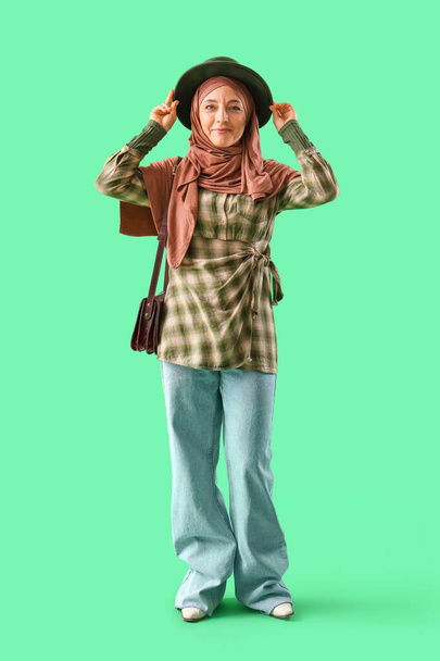 Mulher muçulmana madura em roupas elegantes no fundo verde - Foto, Imagem