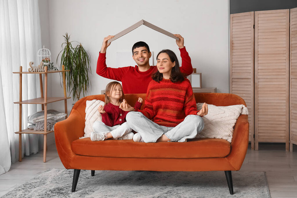 Šťastná rodina s lepenkou snění o jejich novém domě v obývacím pokoji - Fotografie, Obrázek