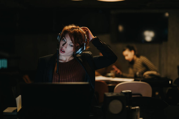 A businesswoman discusses data analytics in a creative office. She works on a new project for market expansion and revenue growth. Late-night dedication reflects their successful sales strategy. - Photo, Image