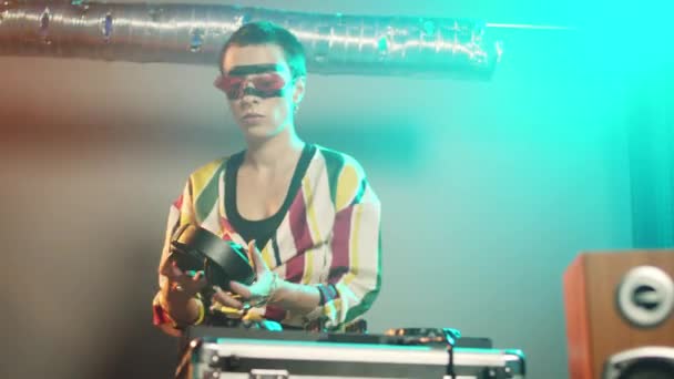 Woman performer mixing sounds at stereo turntables, using audio instruments and disco vinyl to play techno records. DJ musician with crazy makeup using electronics at party. Handheld shot. - Footage, Video