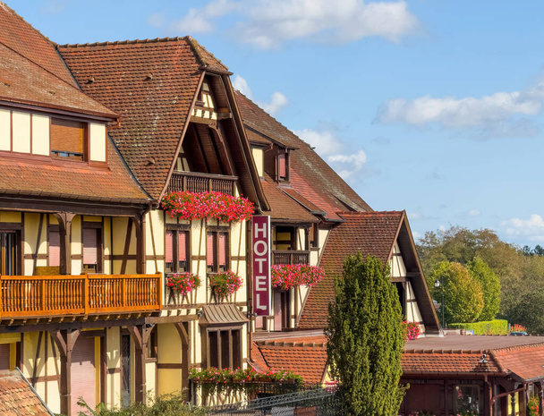 Отель вывески видны на фасаде традиционного деревянного эльзасского дома, воплощая в себе регионы архитектурного шарма - Фото, изображение