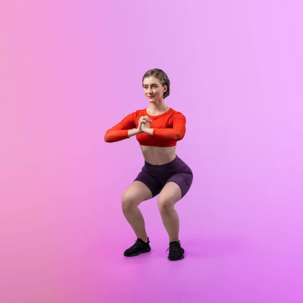 Vücut uzunluğunun tamamı atletik ve sportif genç bir kadın tarafından izole edilmiş arka planda egzersiz pozisyonunda çekilmiştir. Sağlıklı aktif ve vücut bakımı yaşam tarzı. - Fotoğraf, Görsel