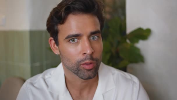 Spanyol férfi beszél kávézó belső portré. Jóképű macsó fehér ingben kommunikál a barátaival, lazít a zöldséges étterem közelségében. Barna borotvált srác mesél történetet beszélgetnek - Felvétel, videó