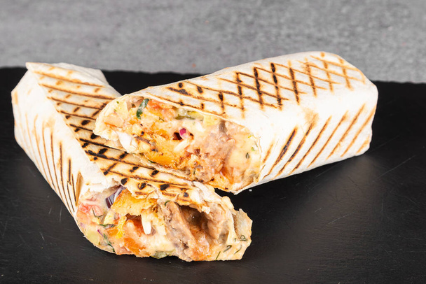 Finom csirke shawarma szósszal, zöldségekkel és sült krumplival egy vágódeszkán - Fotó, kép