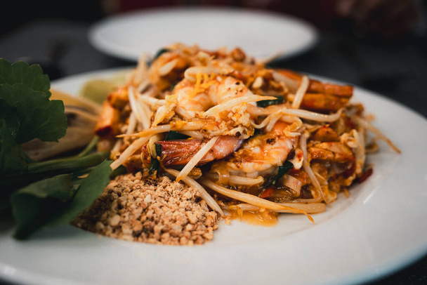 Креветки тайский на белой тарелке подается с арахисом. Закрыть - Фото, изображение