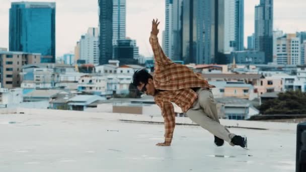 Latynoska tancerka break praktykuje kroki B-boy na dachu z widokiem na miasto lub wieżowiec. Młoda grupa tańca współczesnego wykonująca ruch hip-hopu. Styl, moda, akcja. Odkryty sport 2024. hiphop. - Materiał filmowy, wideo