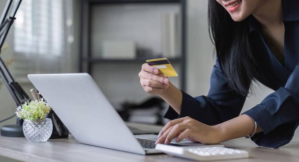 Junge Frau mit Kreditkarte und Laptop online einkaufen oder online Ihre Finanzen planen. - Foto, Bild