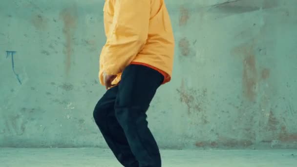 Kaukasische hipster shows of voetstappen oefenen op straat, stedelijke stad. Breek danser voetstap naar hip-hop muziek tijdens het luisteren vanaf de hoofdtelefoon. Outdoor sport 2024. Grijze achtergrond. hiphop. - Video