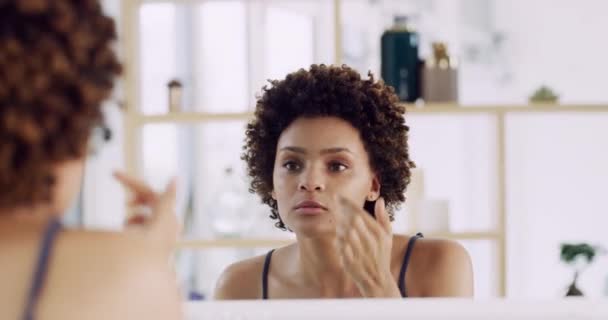 Mulher, cuidados com a pele e espelho do banheiro para dermatologia e limpeza facial. Casa, reflexão e pessoa feminina africana com hidratante e beleza para brilho natural da pele em uma casa de manhã. - Filmagem, Vídeo