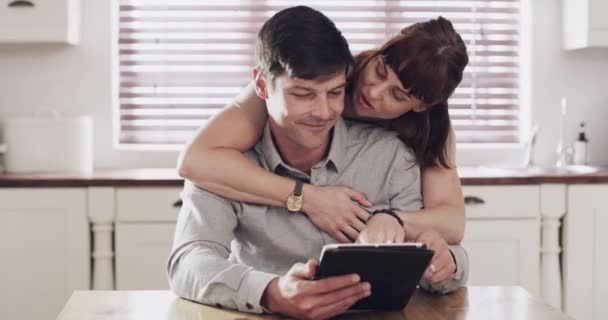 Couple, tablet and hug at home with social media, web video and marriage with tech and happy. Smile, embrace and online with support, love and care together and reading a blog or post in a house. - Footage, Video