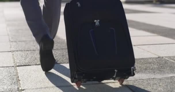 City, suitcase and legs of business man walking to travel, global opportunity or journey from the back. Luggage, bag and closeup of entrepreneur, shoes and street ground, steps and road to airport. - Footage, Video