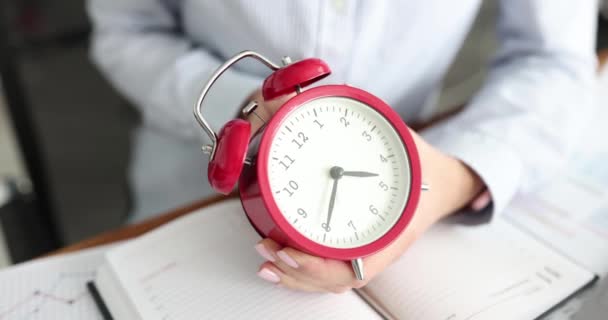 La empresaria traduce el despertador rojo en el lugar de trabajo. Tiempo extra y plazo y concepto de tiempo de parada - Metraje, vídeo