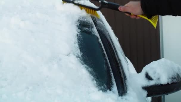 Uomo che toglie la neve dal finestrino dell'auto. Girato con telecamera ad elio rosso in 8K.      - Filmati, video