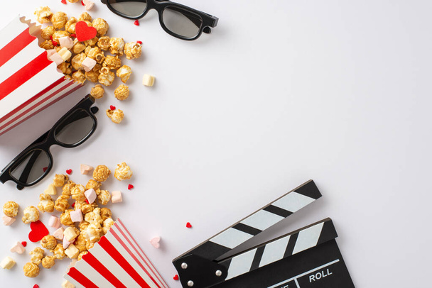 Nostalgic cinema experience at home. Top view photo with a clapperboard, 3D glasses, vintage popcorn boxes, heartwarming decor, capturing the essence of a retro movie night on a white background - Photo, Image