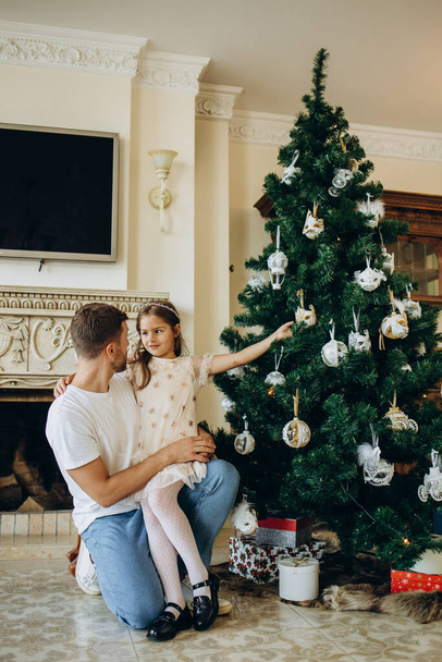 πατέρας και κόρη κοντά το χριστουγεννιάτικο δέντρο - Φωτογραφία, εικόνα