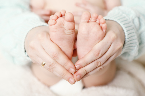 Újszülött baba láb női kézen, közelkép - Fotó, kép