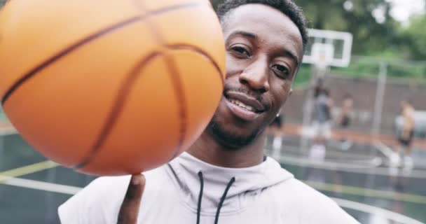 Чорний чоловік, кружляючи баскетболом або обличчям щасливий за фітнес, фізичні вправи або професійний спортсмен на відкритому повітрі на дворі. Африканський спортсмен, портрет або посмішка в тренуванні здоров'я або стріляти в обручі на природі. - Кадри, відео