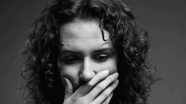 Zamyšlená žena přemýšlející o obtížném rozhodnutí v černobílé, monochromatické klipu dotyčné mladé osoby s rukou v bradě - Fotografie, Obrázek