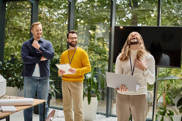 focus op vrolijke man in casual kleding met videocall en zijn wazig collega 's bespreken startup - Foto, afbeelding