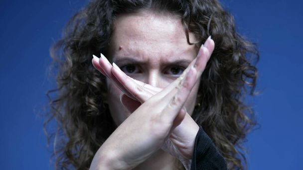 Empörte Frau zeigt mit dem Finger auf Kamera, winkt mit "NEIN" in Ablehnung, Nahaufnahme negativer Körpersprache, die mit den Händen ein "X" macht - Foto, Bild