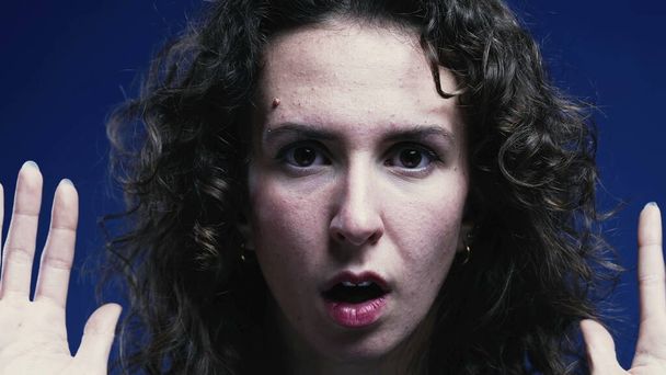 Испуганная женщина реагирует с шоком и открытым ртом, сжатым крупным планом лица - Фото, изображение
