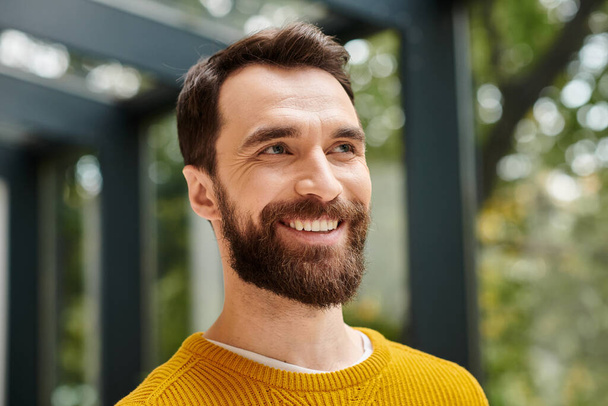 good looking cheerful architect in comfy yellow turtleneck with beard posing and looking away - Photo, Image
