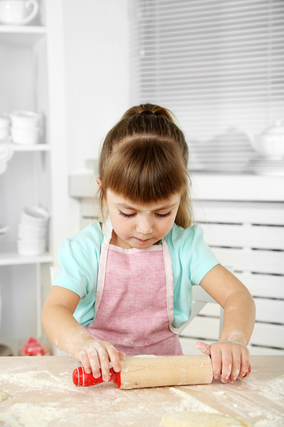 Little girl preparing cookies in kitchen at home - Foto, Bild