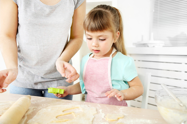 Little girl preparing cookies in kitchen at home - Photo, Image
