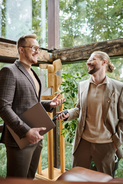 joyeux chefs d'entreprise attrayants avec des lunettes dans des vêtements à la mode discuter de leur démarrage - Photo, image