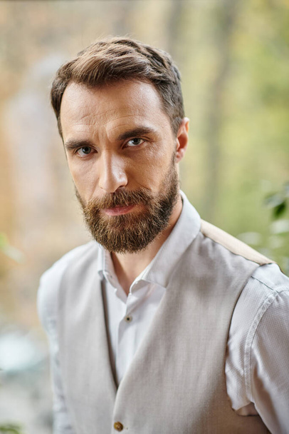 handsome concentrated leader with beard in sophisticated attire looking at camera, business concept - Photo, Image