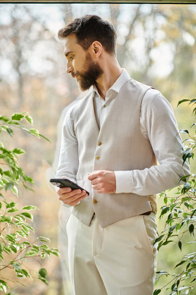 красивий концентрований лідер з бородою у складному вбранні, що тримає телефон, бізнес-концепція - Фото, зображення