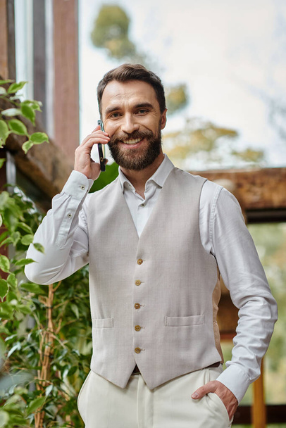 attractive concentrated leader with beard in sophisticated attire talking by phone, business concept - Photo, Image